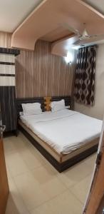 a bedroom with a large bed with white sheets at hotel neelkamal in Ajmer