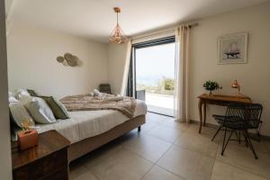 a bedroom with a bed and a desk and a window at villa mare d'argentu - vue mer panoramique in Sari Solenzara +25 photos