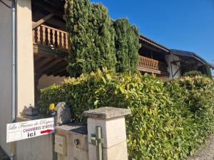 ein Haus mit einem Schild vor einigen Büschen in der Unterkunft La ferme de Rapan Pérouges in Pérouges