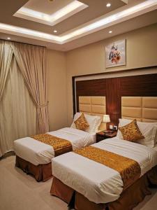 a hotel room with two beds in a bedroom at شقق سما الرفاع للشقق المخدومة in Al Kharj