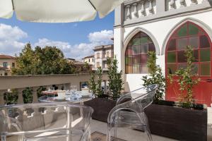 a patio with tables and chairs on a balcony at Villa Garibaldi in Bettolle