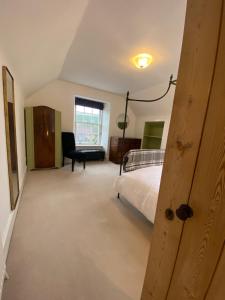 a bedroom with a bed and a chair and a window at Brylach Steading in Aberlour