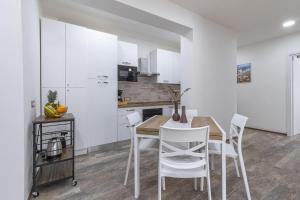 a kitchen and dining room with a table and chairs at Blanche Apartments in Porto Torres