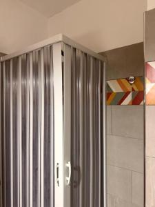 a bathroom with a shower with a metal door at Affittacamere Rosy in Foligno