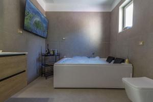 a large bath tub in a bathroom with a toilet at Blanche Apartments in Porto Torres +95 photos