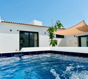 a swimming pool in front of a house at Smart Apartments Facinas, Piscina y tranquilidad cerca de Tarifa y Bolonia in Facinas
