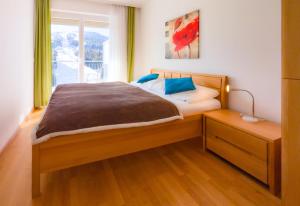 a bedroom with a large bed with a window at Haus CKPK Lux in Sonnenalpe Nassfeld
