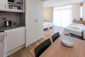 a kitchen with a table, chairs and a refrigerator at Aparthotel Marinada in Salou