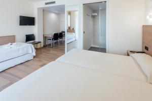 サロウにあるAparthotel Marinadaのベッド2台と鏡が備わるホテルルームです。