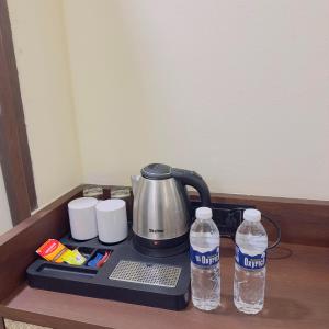 a tea kettle and two bottles of water on a counter at Hotel Liora in Rajkot