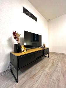 a room with a table with a television on it at Au Cocon Alsacien in Wintzenheim