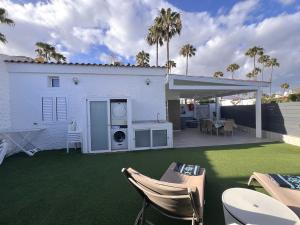 a backyard with a lawn and a white house at Suite Coco in Maspalomas +37 photos