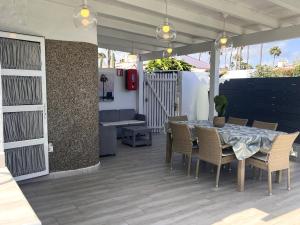 a patio with a table and chairs and a couch at Suite Coco in Maspalomas