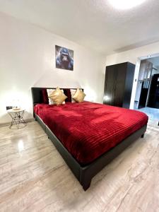 a bedroom with a large bed with a red comforter at Au Cocon Alsacien in Wintzenheim