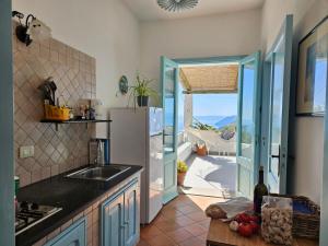 a kitchen with a refrigerator and a view of the ocean at Villa Paradiso - spectacular sea view over volcanoes in Piano Conte