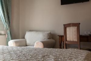 a bedroom with a chair and a bed and a chair at Villa Garibaldi in Bettolle