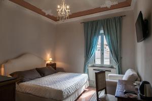 a bedroom with a bed and a window and a chandelier at Villa Garibaldi in Bettolle