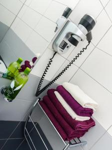 a towel rack with towels and a blow dryer in a bathroom at Charming Apartment in Zagreb