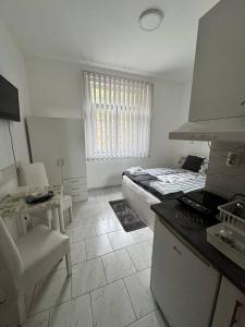 a white kitchen with a bed and a table at Vila Cirkovic - 200m od mermernog setalista in Soko Banja