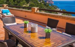a wooden table and chairs on a balcony with the ocean at Vistamar in Canyamel