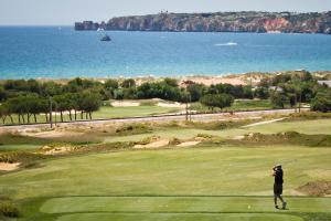 a man swinging a golf club on a golf course at Palmares Beach House Hotel - Adults Only in Lagos
