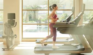 a woman running on a treadmill in a gym at Taj Swarna, Amritsar in Amritsar