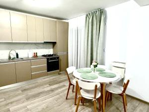 a kitchen with a table and chairs in a room at Servio apart in Otopeni +6 photos