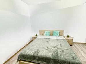 a bedroom with a bed with two blue pillows at Servio apart in Otopeni