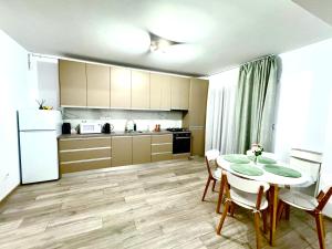 a kitchen and dining room with a table and chairs at Servio apart in Otopeni