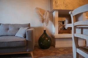 a living room with a couch and a vase with feathers at Al Cortiletto Apartments in Gardone Riviera