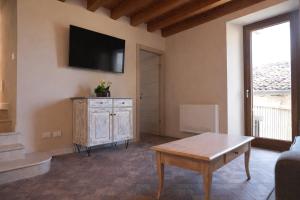 a living room with a flat screen tv on the wall at Al Cortiletto Apartments in Gardone Riviera
