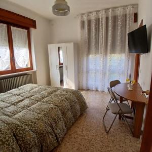 a bedroom with a bed and a desk and a table at Casa Bellotta in Suno +37 photos