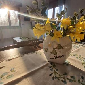 a vase filled with yellow flowers on a table at Casa Bellotta in Suno