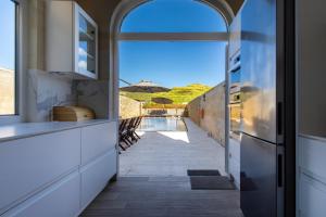 a kitchen with an open door leading to a patio at Solaris Holiday Home in Għasri