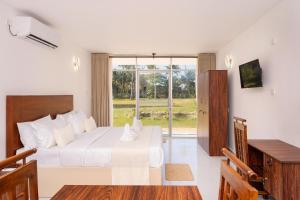 a bedroom with a bed and a table and a window at Madiha Beach Resort in Matara