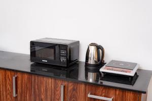a black counter top with a microwave and a coffee maker at Madiha Beach Resort in Matara +18 photos
