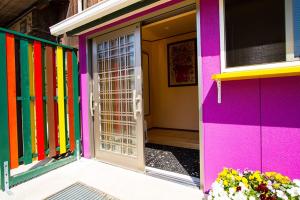 una porta colorata di una casa con fiori di Mrs. Maroulla's HOUSE a Naoshima