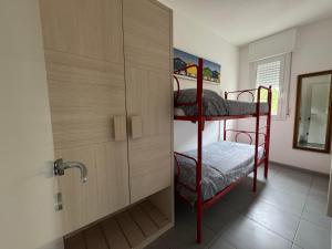 a bedroom with two bunk beds and a cabinet at Appartamenti al Cigno in Lignano Sabbiadoro