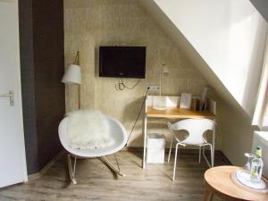 a living room with two white chairs and a table at Hotel Restaurant Anders in Schwarzenbruck