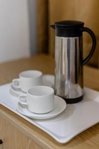 three cups and saucers on a counter with a coffee pot at Hotel Ganga Stone in Rāiwāla