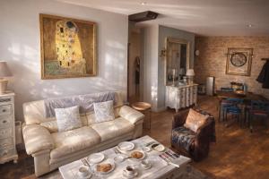 a living room with a couch and a table at La Salamandre - Un écrin médiéval pour vos souvenirs - Imaginez-vous, réveillé par le murmure de Sarlat, dans un appartement spacieux et chaleureux, au cœur de la Cité classée - 2 chambres - Une magie à vivre sans modération - Réservez dès maintenant ! in Sarlat-la-Canéda
