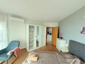 a living room with a bed and a chair at Apartment Sunrise Pomorie in Pomorie