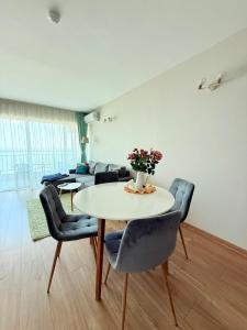 a living room with a table and chairs and a couch at Apartment Sunrise Pomorie in Pomorie +12 photos