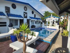 a swimming pool in front of a white building at Pio's Place Hidden Resort in Namonitan