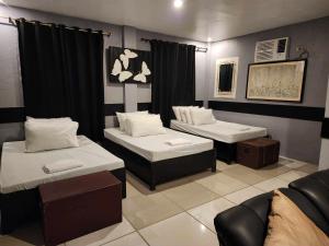 a room with two beds and a couch at Pio's Place Hidden Resort in Namonitan