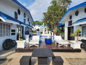 a patio with white chairs and a table at Pio's Place Hidden Resort in Namonitan