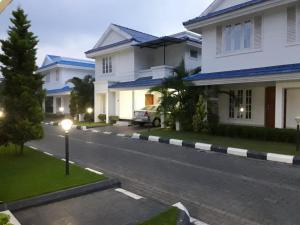 a street with white houses and a car on the road at HK villas in Edappally