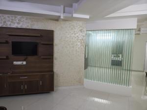 a living room with a tv and a glass wall at HK villas in Edappally +52 photos