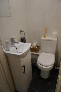 a bathroom with a white toilet and a sink at Portside Apartment in Greenock