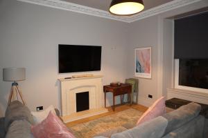 a living room with a couch and a fireplace at Portside Apartment in Greenock